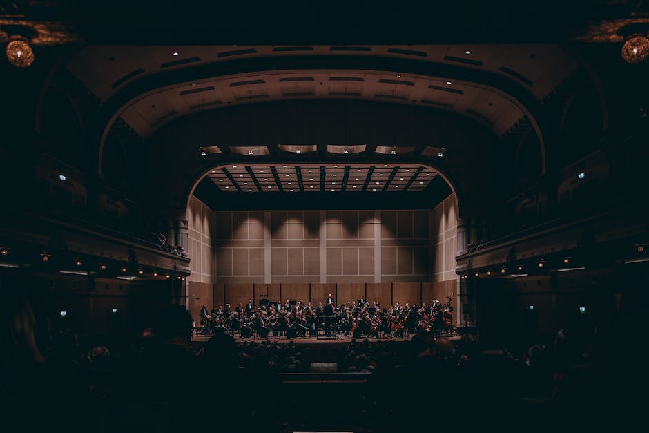 Imagen de una Banda Sinaloense en pleno concierto, con músicos tocando diversos instrumentos y un gran público disfrutando de la música.